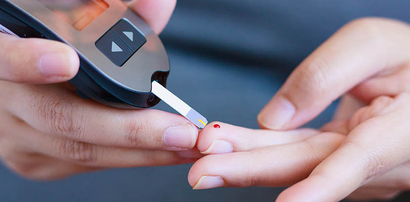 A diabetic person is using a diabetes tests to check blood sugars