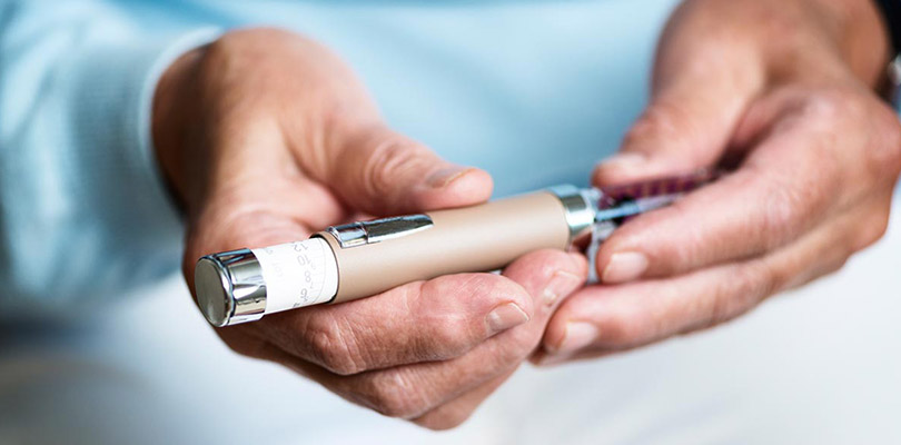 A diabetic holds an insulin pen